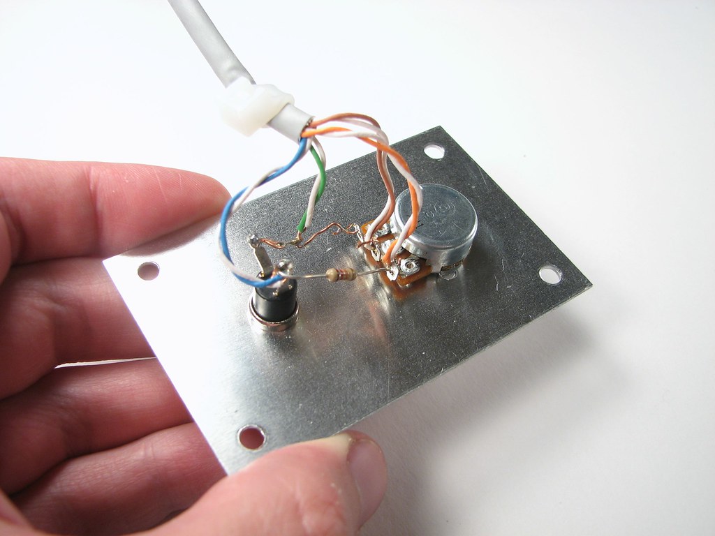 The internal circuit board and components of a disassembled game controller laid flat.
