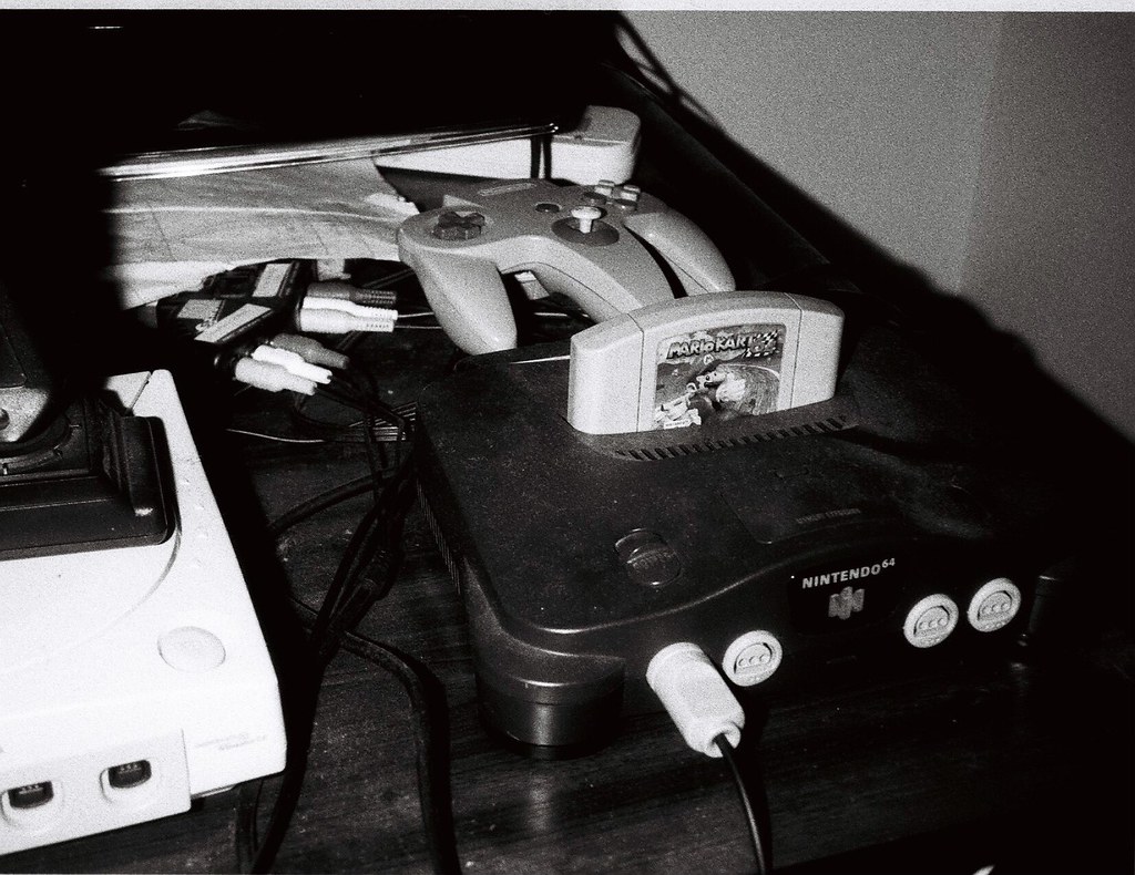 A Nintendo 64 console with a Mario Kart 64 cartridge inserted, photographed against a plain background.